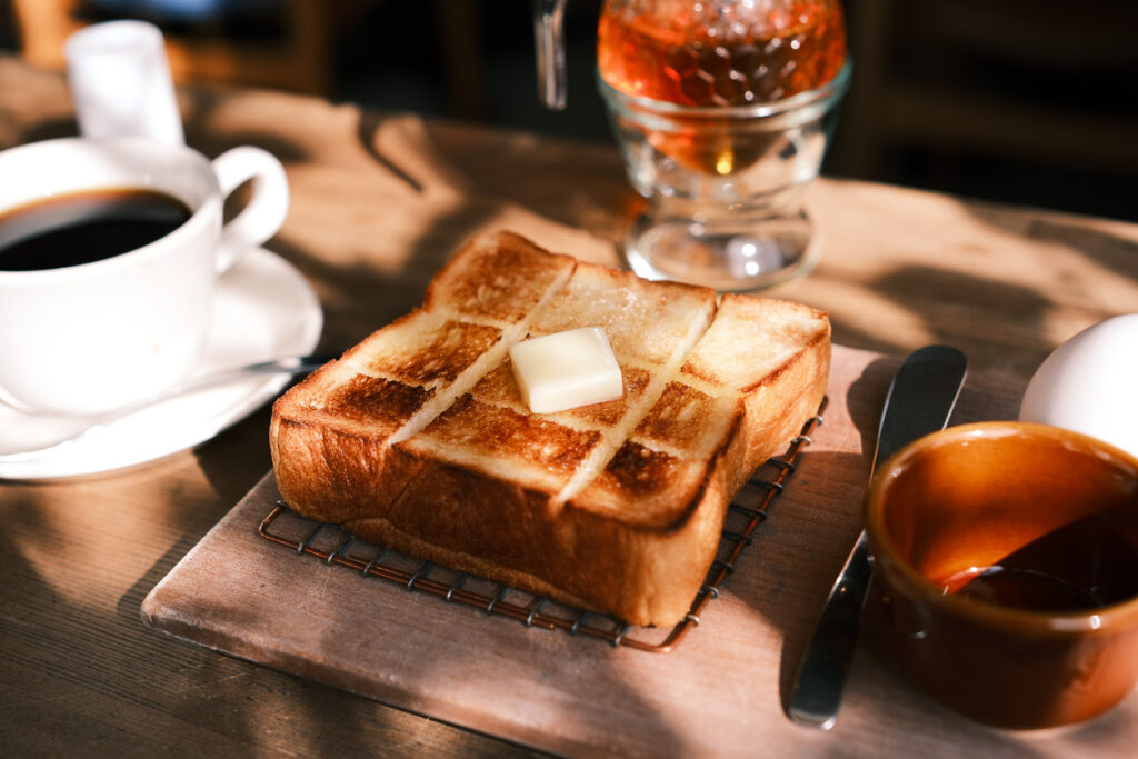 木のテーブルに置かれたトーストとコーヒー